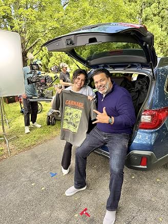 Sunil behind the scenes beside an open car trunk