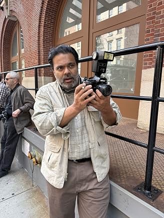 Sunil with a camera outside a building