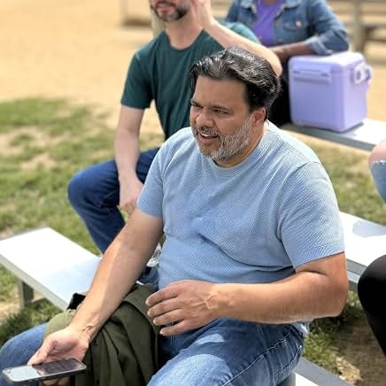Sunil seated outdoors in character