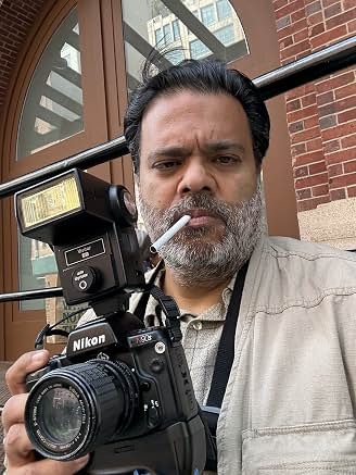Sunil holding a camera behind the scenes