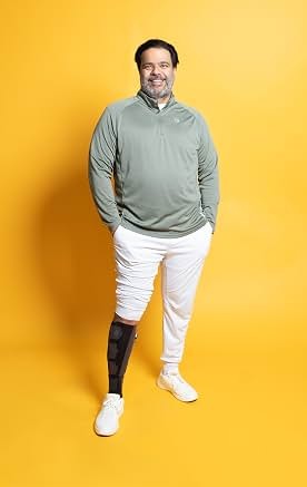 Sunil in a studio portrait against a yellow background